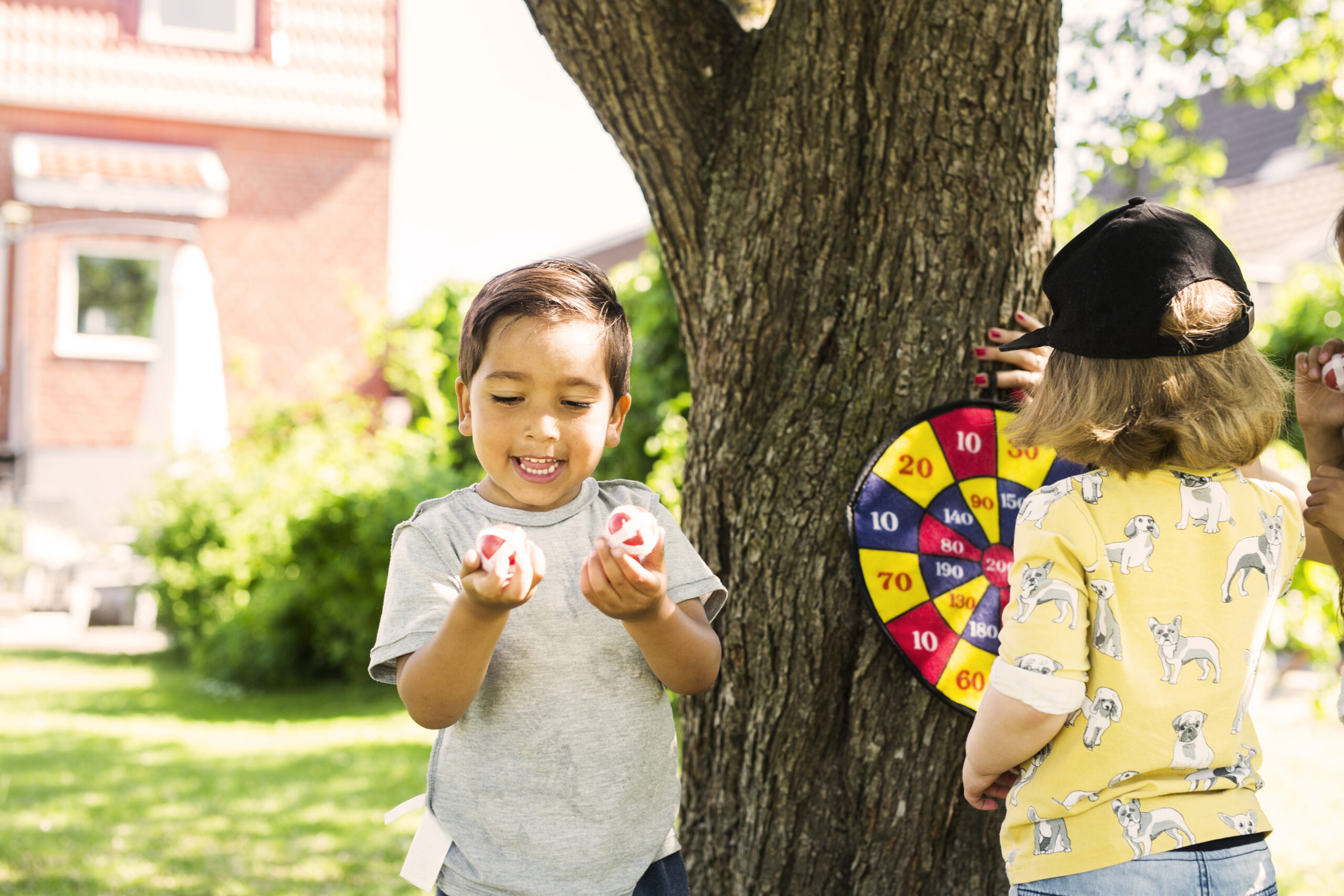 Children (2-3, 6-7) playing in in front yard